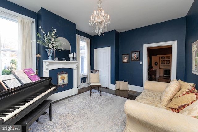 sitting room with hardwood / wood-style floors and an inviting chandelier