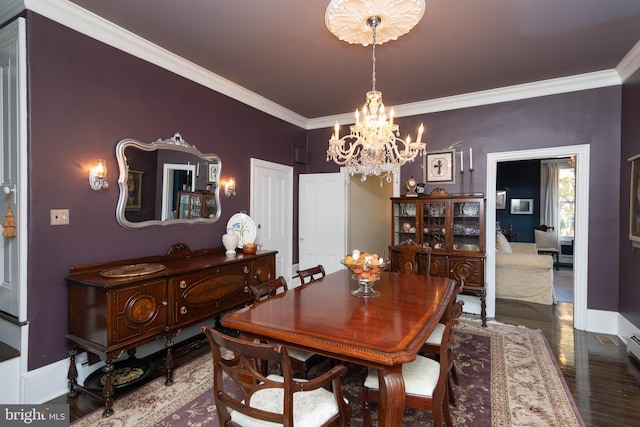 dining room with hardwood / wood-style floors, an inviting chandelier, and ornamental molding