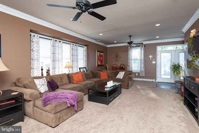 carpeted living room featuring ceiling fan, a healthy amount of sunlight, a baseboard heating unit, and ornamental molding