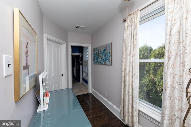 hallway featuring a healthy amount of sunlight and dark hardwood / wood-style flooring