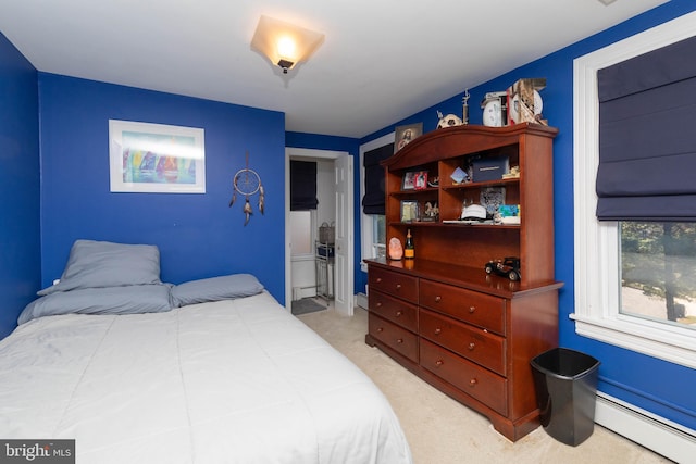 bedroom with light carpet, a baseboard radiator, and ensuite bath