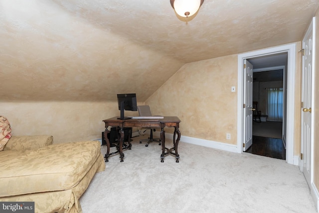 home office featuring light carpet and lofted ceiling