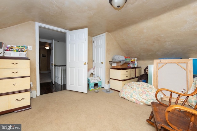 sitting room with light colored carpet, baseboard heating, and vaulted ceiling