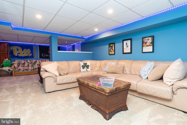 carpeted living room featuring a drop ceiling