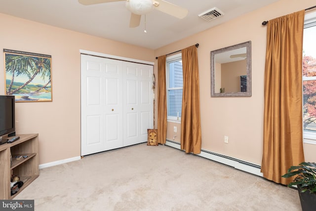 carpeted bedroom with a closet, multiple windows, and ceiling fan