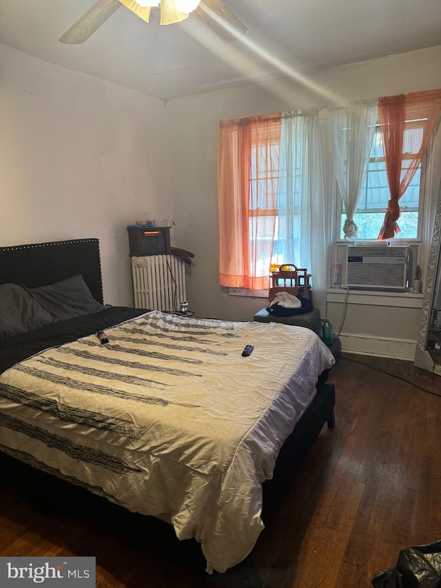 bedroom with ceiling fan, cooling unit, dark wood-type flooring, and multiple windows