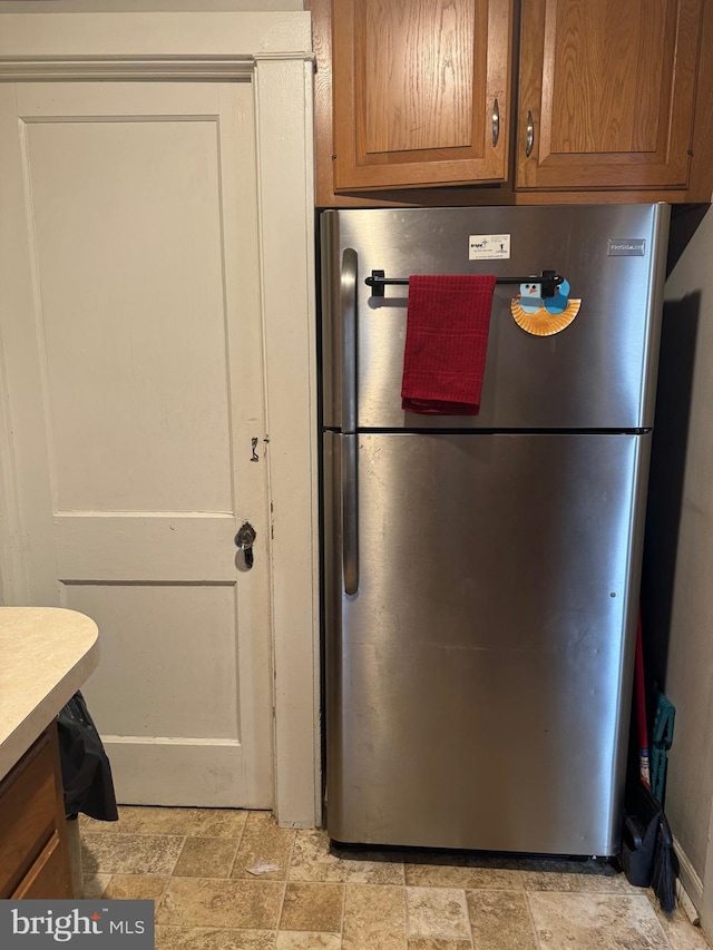 533 Hamilton St, Lancaster, PA 17602 - kitchen featuring freestanding refrigerator, stone finish flooring, light countertops, and brown cabinets