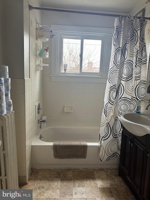 bathroom with vanity, tile walls, radiator, and shower / tub combo with curtain