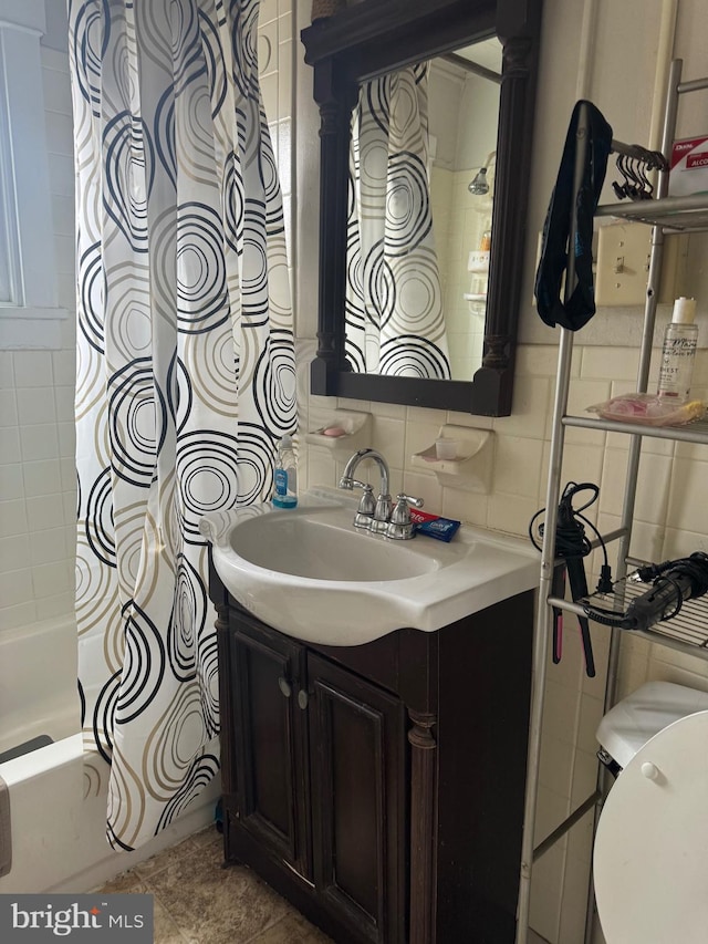 bathroom with decorative backsplash, shower / bath combo, vanity, and tile walls