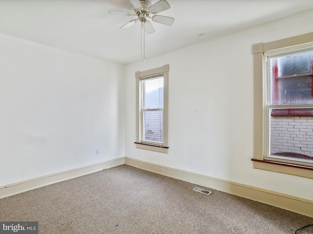 empty room with ceiling fan and carpet