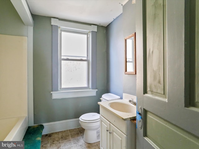 bathroom with vanity, toilet, and a tub