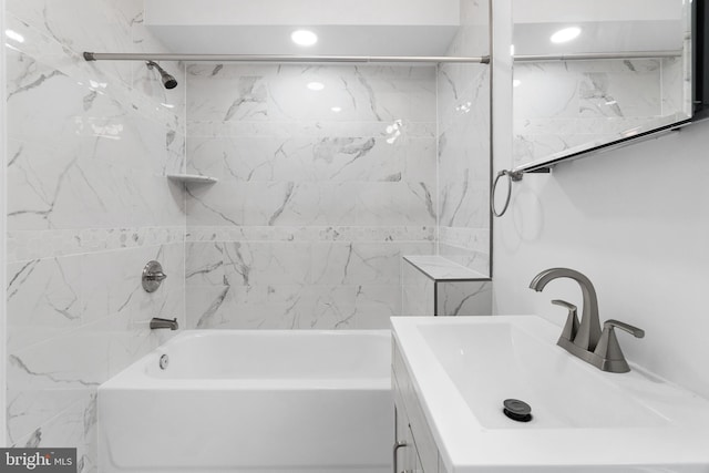 bathroom featuring vanity and tiled shower / bath