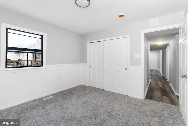 unfurnished bedroom with a closet and dark hardwood / wood-style flooring