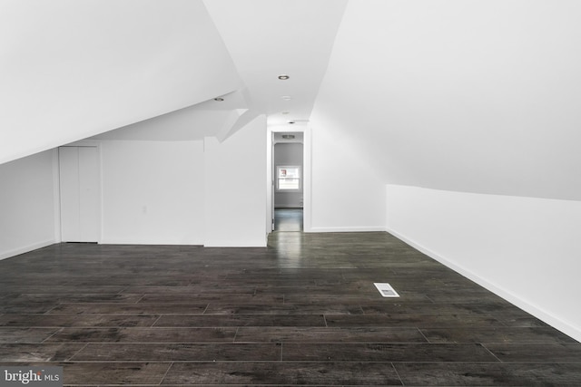 bonus room with dark hardwood / wood-style flooring and vaulted ceiling