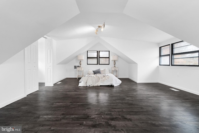 unfurnished bedroom featuring vaulted ceiling and dark wood-type flooring