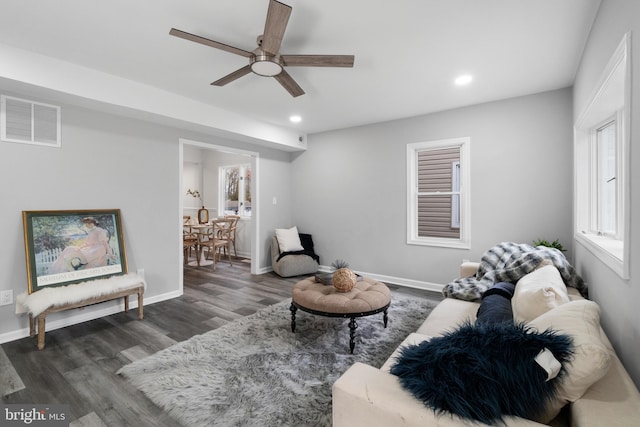 living room featuring ceiling fan and dark hardwood / wood-style flooring