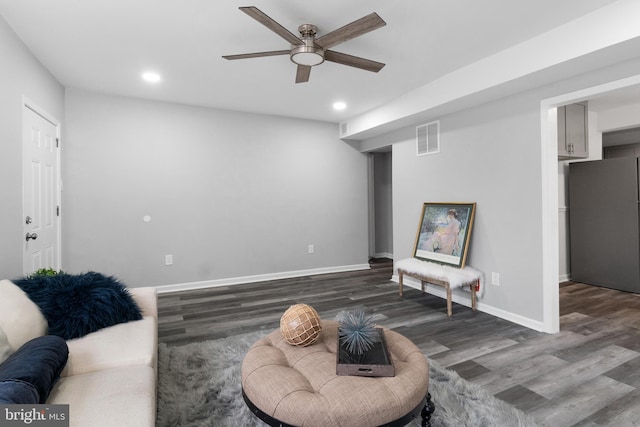 living room featuring ceiling fan and dark hardwood / wood-style flooring