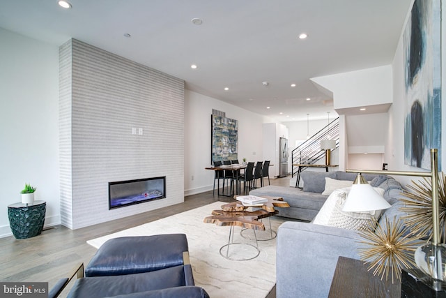 living room featuring light wood-type flooring and a fireplace