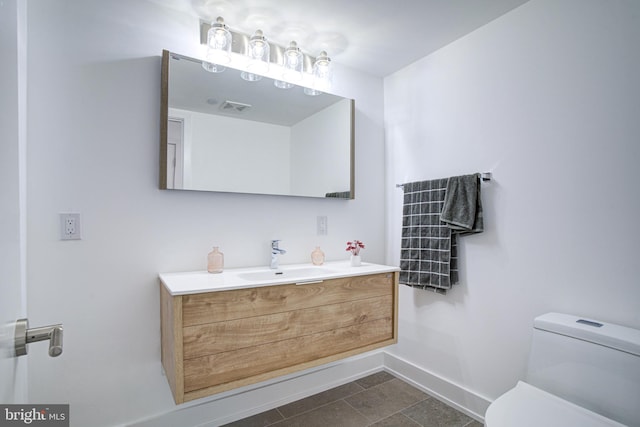 bathroom featuring tile patterned floors, vanity, and toilet