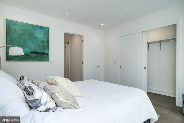 bedroom with dark hardwood / wood-style flooring and a closet