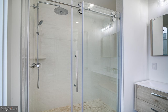 bathroom with a shower with door and vanity