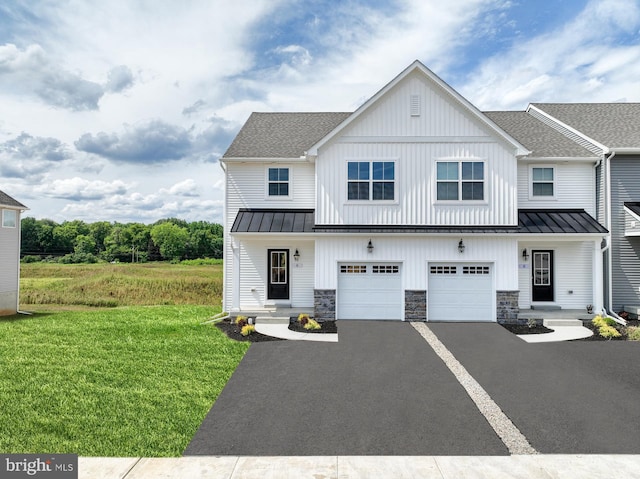 modern farmhouse style home with a front yard and a garage