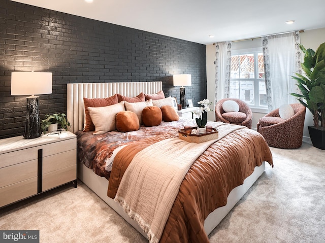 carpeted bedroom with brick wall