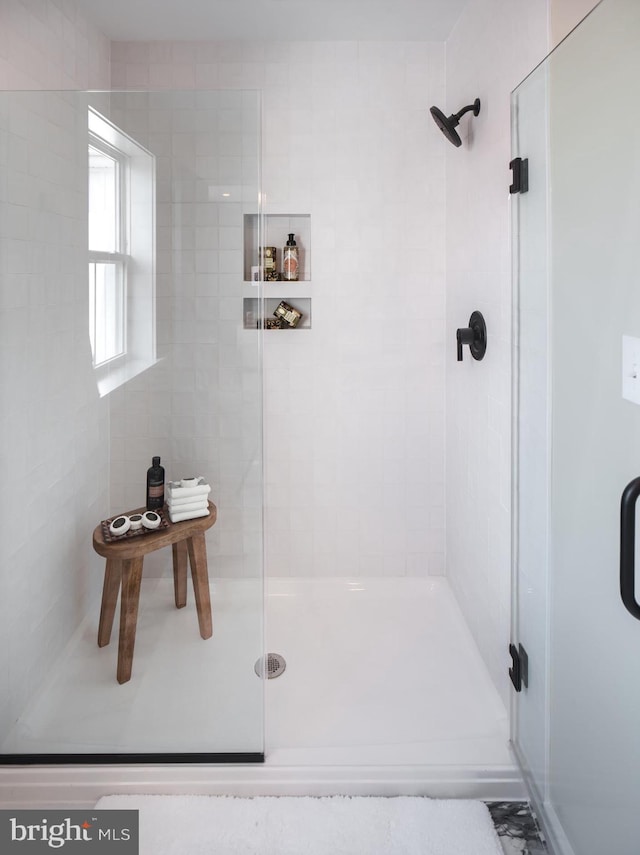 bathroom featuring a shower with shower door