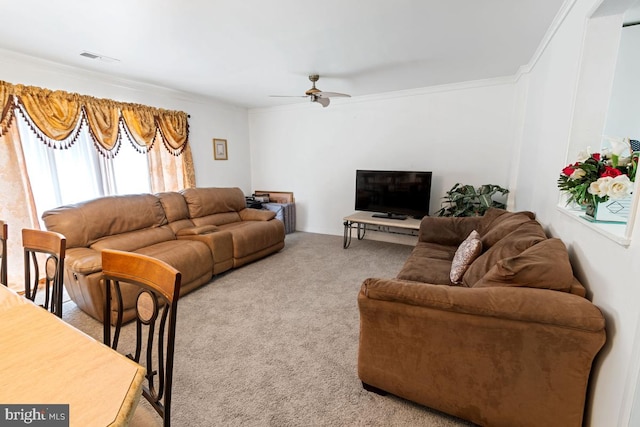 carpeted living room featuring ceiling fan and crown molding