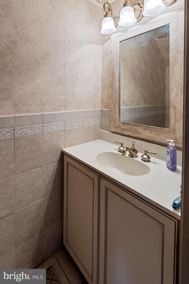 bathroom featuring vanity and tile walls