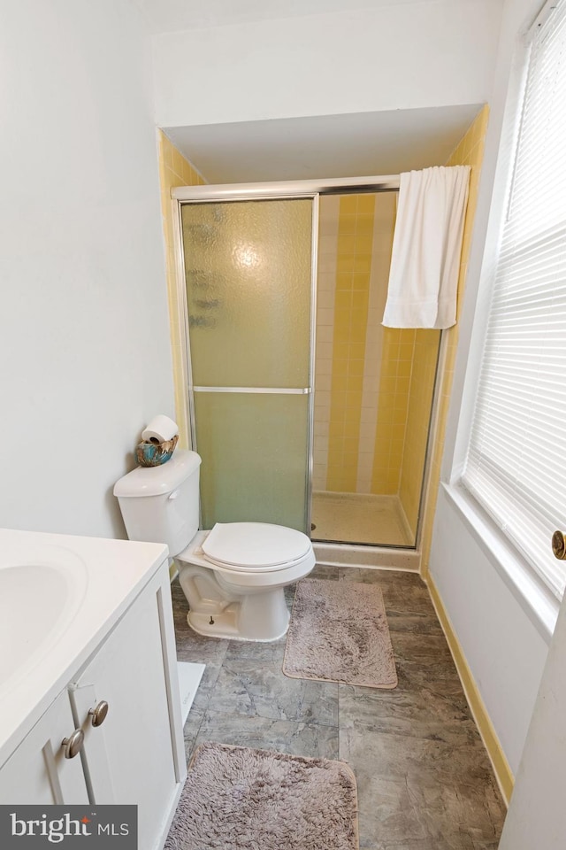 bathroom with vanity, toilet, and a shower with shower door