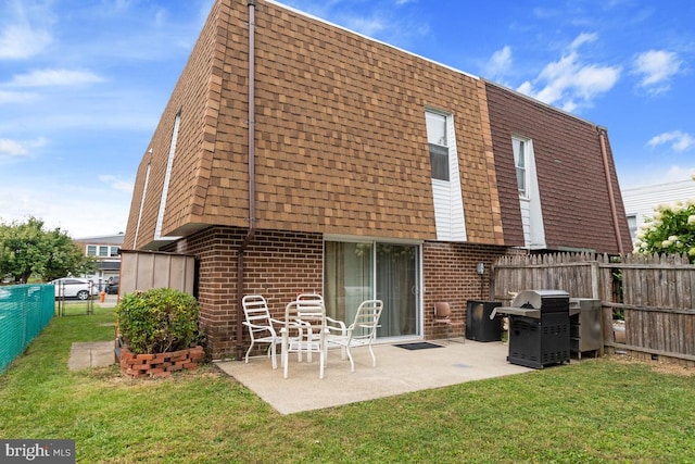 rear view of property with a lawn and a patio area