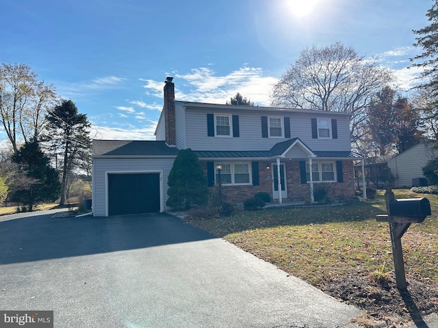 view of front property featuring a garage and a front lawn