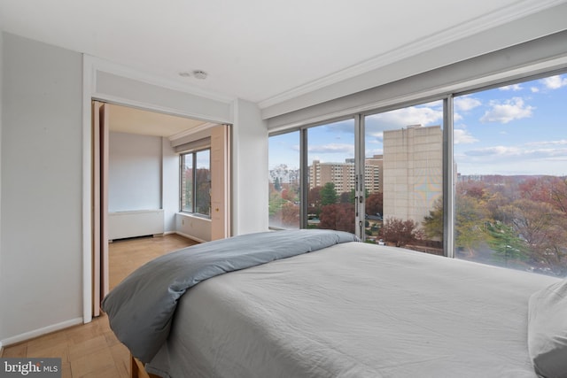 bedroom with multiple windows, crown molding, and light parquet flooring