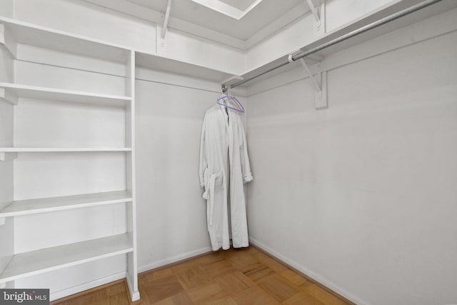 walk in closet featuring parquet flooring