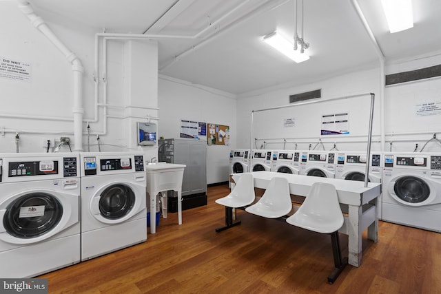 clothes washing area with hardwood / wood-style flooring and washing machine and clothes dryer