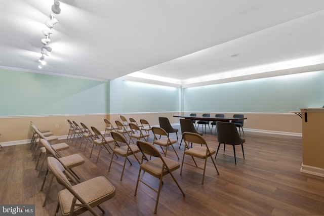 dining room with crown molding, dark hardwood / wood-style flooring, and track lighting