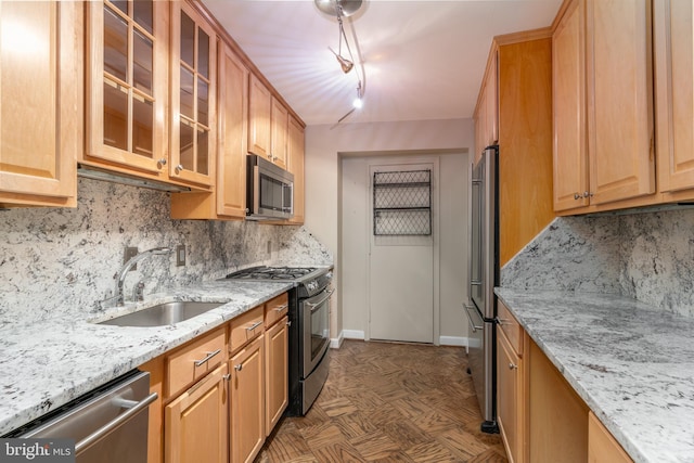 kitchen with backsplash, light stone counters, sink, and stainless steel appliances