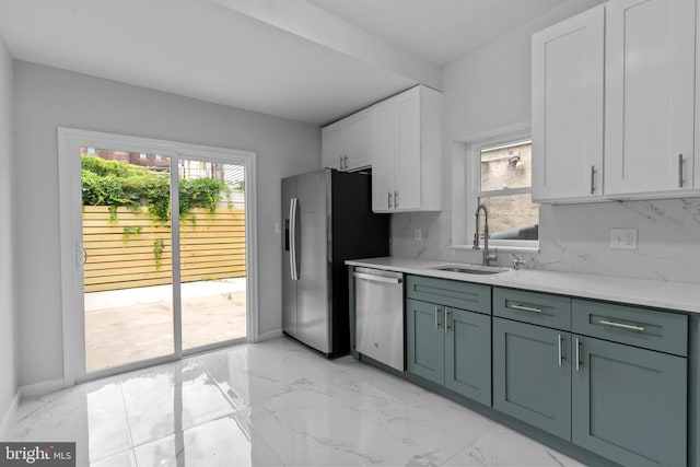 kitchen with decorative backsplash, appliances with stainless steel finishes, white cabinetry, and sink