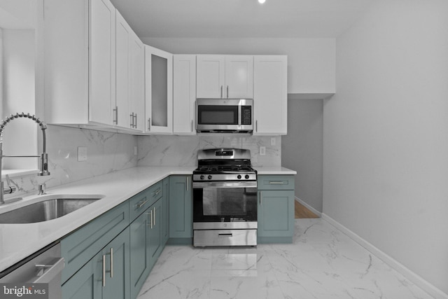 kitchen featuring decorative backsplash, sink, white cabinetry, and stainless steel appliances