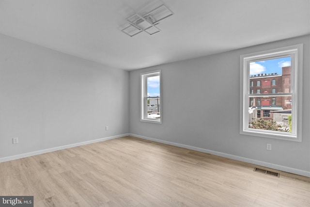 empty room with light hardwood / wood-style flooring