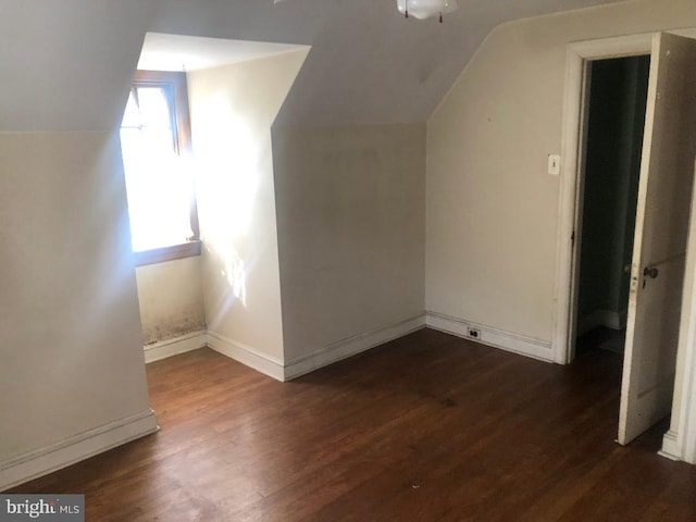 additional living space with dark hardwood / wood-style floors and vaulted ceiling