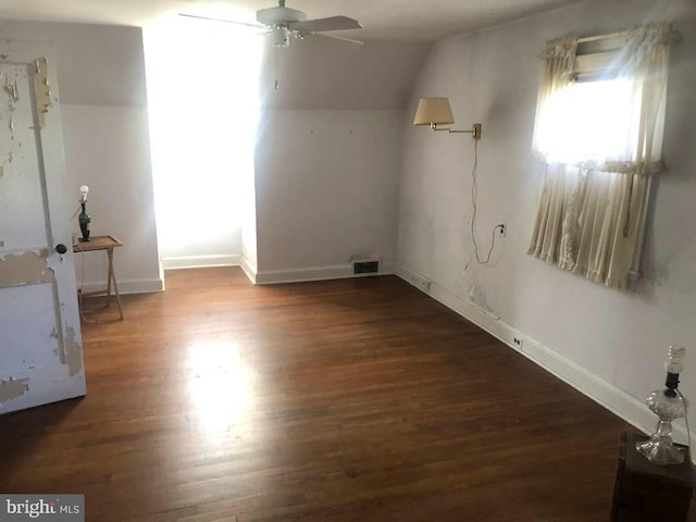 additional living space featuring dark hardwood / wood-style floors, vaulted ceiling, and ceiling fan