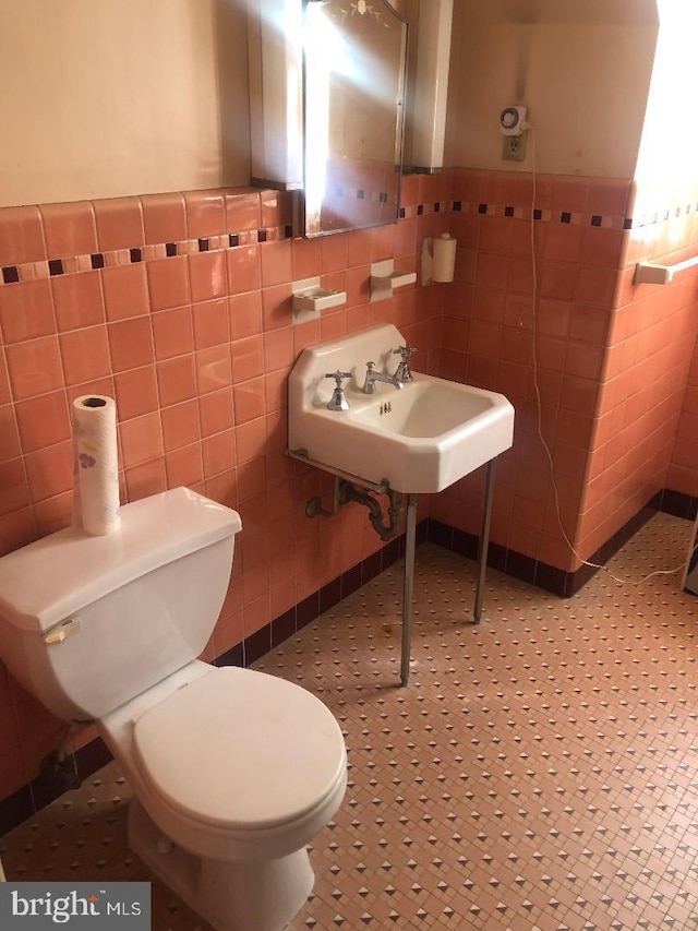 bathroom featuring tile patterned floors, tile walls, and sink