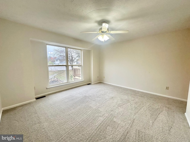 spare room with ceiling fan, carpet floors, and a textured ceiling