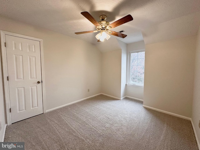 unfurnished room with a textured ceiling, carpet floors, and ceiling fan