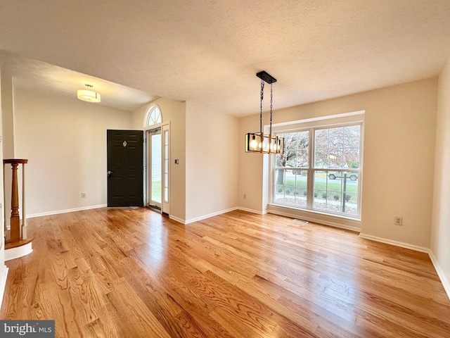 interior space featuring a chandelier, a textured ceiling, and light hardwood / wood-style flooring