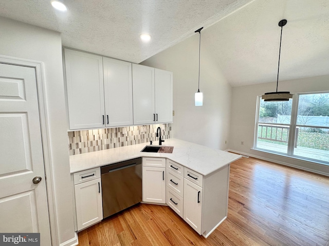 kitchen with dishwasher, kitchen peninsula, decorative light fixtures, and white cabinetry