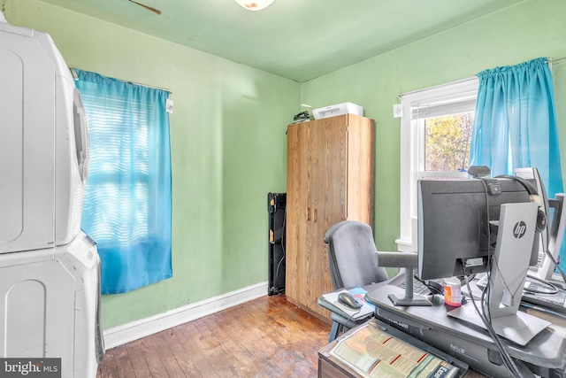 office featuring wood-type flooring and stacked washer and clothes dryer