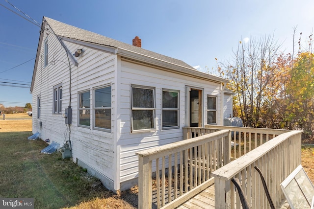 view of front of property featuring a deck and a front lawn